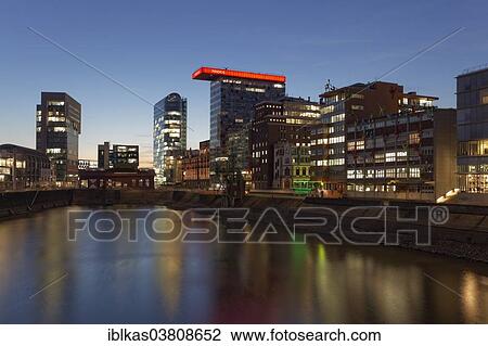 Stock Image - "Office buildings in Media Harbour at the blue hour, Dusseldorf, North Rhine-Westphalia, Germany, Europe". Fotosearch