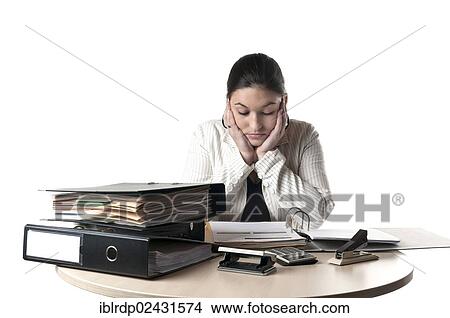 Picture - Office worker sitting at a desk with files. Fotosearch