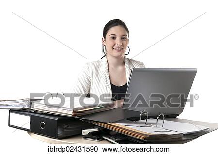 Office worker sitting at a desk with file folders and a laptop View Large Photo Image Stock Image - Office worker sitting at a desk with file folders and a laptop. Fotosearch