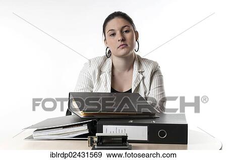 Stock Photo - Office worker sitting at a desk with files. Fotosearch