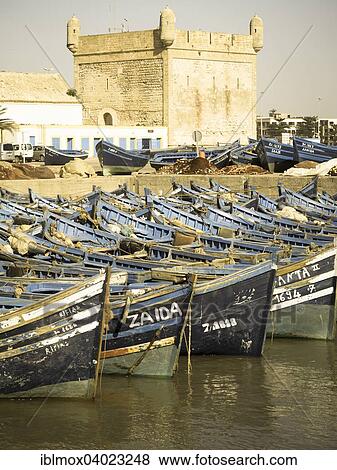 "Old blue fishing boats in the port of Essaouira, behind the fortress of Essaouira, Unesco World Heritage Site, Morocco, Africa" View Large Photo Image Stock Photo - "Old blue fishing boats in the port of Essaouira, behind the fortress of Essaouira, Unesco World Heritage Site, Morocco, Africa". Fotosearch