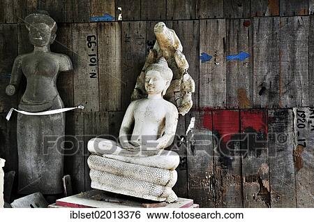 "Old Buddha statue and female torso of a deity made of stone in front of a wooden wall, Cambodia, Southeast Asia, Asia" View Large Photo Image Stock Photograph - "Old Buddha statue and female torso of a deity made of stone in front of a wooden wall, Cambodia, Southeast Asia, Asia". Fotosearch