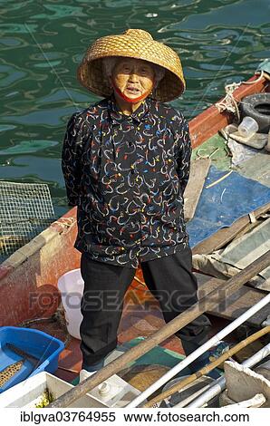 Stock Photography - "Old Chinese fishmonger with straw hat on her boat, Sai Kung, Hong Kong, China, Asia". Fotosearch