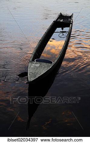 Stock Photo - "Old, flooded boat at sunset in Laos, Southeast Asia, Asia". Fotosearch