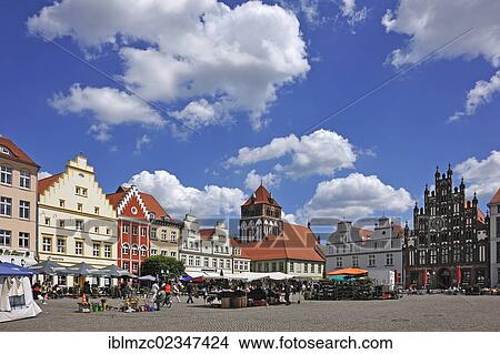 Picture - "Old gabled houses on Marktplatz square, stalls in the foreground, the steeple of St. Marienkirche church at the back, a town house on the right, brick architecture around 1400, market, Greifswald, Mecklenburg-Western Pomerania, Germany, Europe". Fotosearch