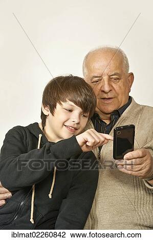 Old man and a boy with a smartphone View Large Photo Image Stock Image - Old man and a boy with a smartphone. Fotosearch