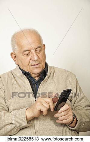 Stock Image - Old man with a smartphone. Fotosearch