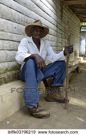 "Old man with stick sitting in front of the house, Village Morin in Leogane, Haiti, North America" View Large Photo Image Stock Photo - "Old man with stick sitting in front of the house, Village Morin in Leogane, Haiti, North America". Fotosearch