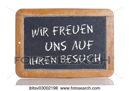 Stock Photo - "Old school blackboard with the words WIR FREUEN UNS AUF IHREN BESUCH, German for We are looking forward to your visit". Fotosearch