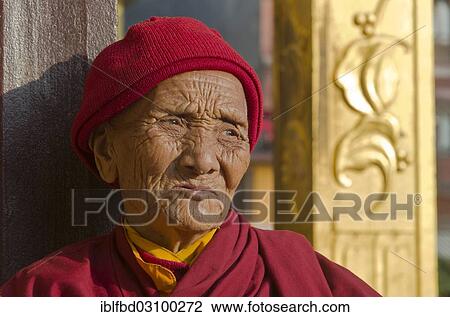 Stock Image - "Old Tibetan woman, dressed in red, portrait, Kathmandu, Kathmandu District, Bagmati Zone, Nepal, Asia". Fotosearch