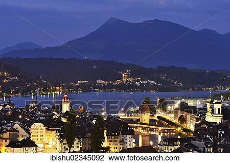 Stock Image - "Old town of Lucerne with Chapel Bridge and water tower at dusk, Rigi at back, Lucerne, Switzerland, Europe". Fotosearch