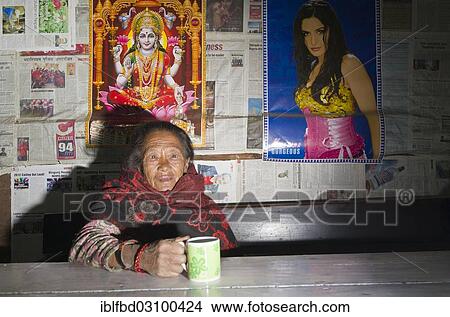 "Old woman drinking tea in a local restaurant, some posters at the wall behind, Shivalaya, Solukhumbu District, Sagarmatha Zone, Nepal, Asia" View Large Photo Image Picture - "Old woman drinking tea in a local restaurant, some posters at the wall behind, Shivalaya, Solukhumbu District, Sagarmatha Zone, Nepal, Asia". Fotosearch