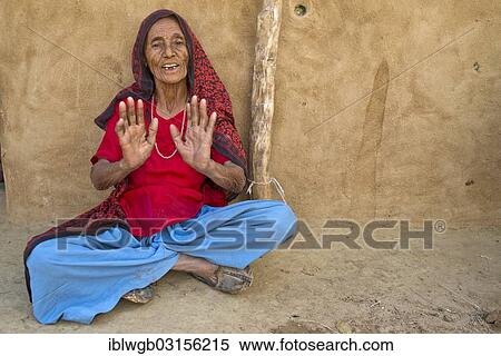 "Old woman sitting on the ground in front of her house gesticulating, Wuste Thar, Rajasthan, India, Asia" View Large Photo Image Stock Photography - "Old woman sitting on the ground in front of her house gesticulating, Wuste Thar, Rajasthan, India, Asia". Fotosearch