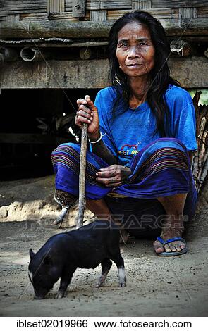 "Old woman with a stick sitting in front of a bamboo hut, small piglet standing in front of her, in a village on the Mekong River, Laos, Southeast Asia, Asia" View Large Photo Image Stock Photograph - "Old woman with a stick sitting in front of a bamboo hut, small piglet standing in front of her, in a village on the Mekong River, Laos, Southeast Asia, Asia". Fotosearch