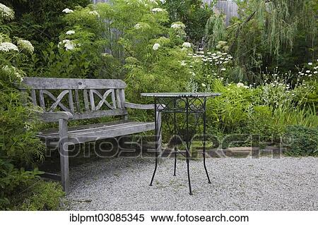 "Old wooden sitting bench and bistro style table in a garden in summer, property released for book, calendar, magazine, newspaper and editorial use only, Quebec Province, Canada, North America" View Large Photo Image Stock Photography - "Old wooden sitting bench and bistro style table in a garden in summer, property released for book, calendar, magazine, newspaper and editorial use only, Quebec Province, Canada, North America". Fotosearch