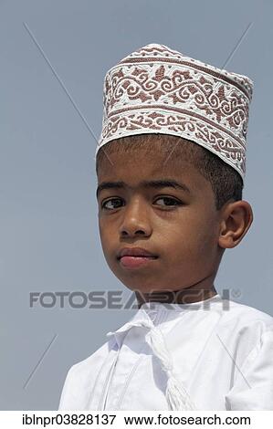 Stock Photo - "Omani boy wearing a traditional cap called a Kummah, portrait, Sur, Ash Sharqiyah province, Sultanate of Oman, Arabian Peninsula". Fotosearch