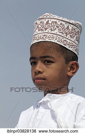 Stock Photo - "Omani boy wearing a traditional cap called a Kummah, portrait, Sur, Ash Sharqiyah province, Sultanate of Oman, Arabian Peninsula". Fotosearch