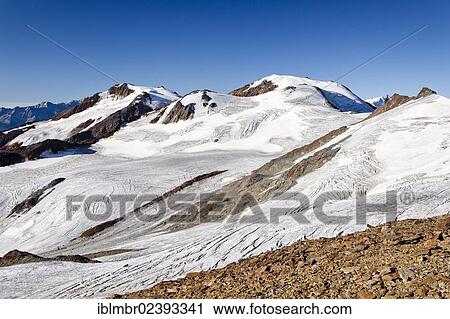 Stock Image - "On the summit ridge on the way to the summit of Zufallspitze mountain above Martellerhuette mountain lodge in the Martelltal valley, Monte Vioz mountain at the back, province of Bolzano-Bozen, Italy, Europe". Fotosearch