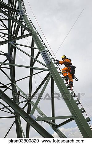 "Overhead transmission cable installer climbing a mast to install insulated cable on a newly built high-voltage transmission mast, Monchenholzhausen, Thuringia, Germany, Europe" View Large Photo Image Stock Image - "Overhead transmission cable installer climbing a mast to install insulated cable on a newly built high-voltage transmission mast, Monchenholzhausen, Thuringia, Germany, Europe". Fotosearch