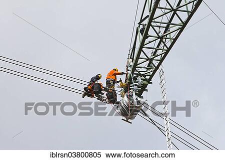 "Overhead transmission cable installers installing insulated cable on the cross arm of a newly built high-voltage transmission mast, Monchenholzhausen, Thuringia, Germany, Europe" View Large Photo Image Stock Photography - "Overhead transmission cable installers installing insulated cable on the cross arm of a newly built high-voltage transmission mast, Monchenholzhausen, Thuringia, Germany, Europe". Fotosearch