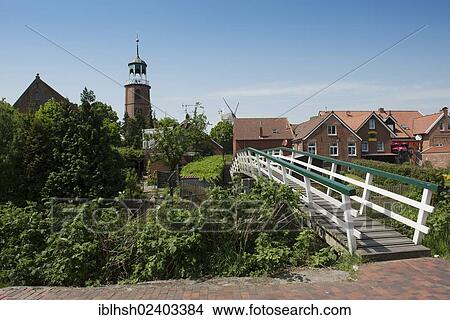 "Overlooking the picturesque fishing village of Ditzum, Evangelical Protestant Church and bridge over Siel Tief river course, houses behind, Rheiderland, East Frisia, Germany, Europe" View Large Photo Image Picture - "Overlooking the picturesque fishing village of Ditzum, Evangelical Protestant Church and bridge over Siel Tief river course, houses behind, Rheiderland, East Frisia, Germany, Europe". Fotosearch