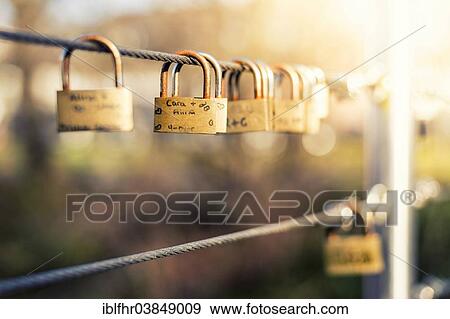 "Padlocks as love locks hanging next to each other on a bridge railing, Grevenbroich, North Rhine-Westphalia, Germany, Europe" View Large Photo Image Stock Photo - "Padlocks as love locks hanging next to each other on a bridge railing, Grevenbroich, North Rhine-Westphalia, Germany, Europe". Fotosearch