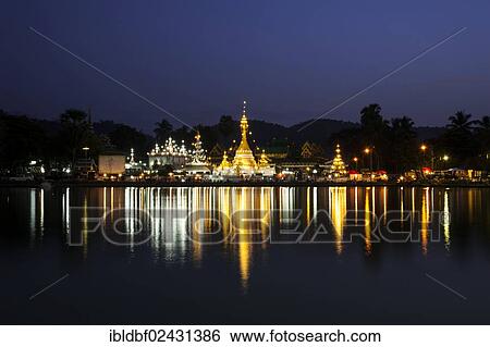 Stock Photograph - "Pagoda or Chedi at dusk, magic hour, reflections in the Nong Jong Kham Lake, temple complex of Wat Jong Kham or Chong Kham and Wat Jong Klang or Chong Klang, Mae Hong Son, Northern Thailand, Thailand, Asia". Fotosearch