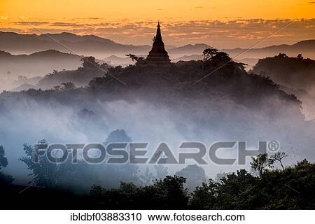 Stock Image - "Pagoda surrounded by trees, in the mist, in the morning light, Mrauk U, Sittwe District, Rakhine State, Myanmar, Asia". Fotosearch