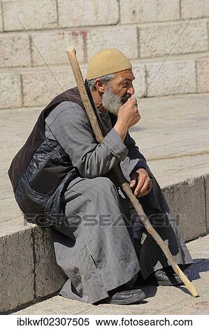Stock Photography - "Palestinian man sitting on the steps outside the Damascus Gate in front of the Old City, Jerusalem, Israel, Middle East, Southwest Asia, Asia". Fotosearch