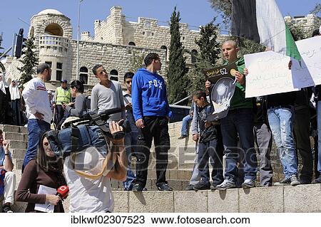Stock Image - "Palestinians demonstrating peacefully with placards and posters against the Israeli settlement policy in front of a camera at the Damascus Gate outside the Old City, Jerusalem, Israel, Middle East, Southwest Asia, Asia". Fotosearch
