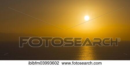 Stock Image - "Panorama, sunset in Los Gigantes, Puerto de Santiago, behind the island of Gomera, Tenerife, Canary Islands, Spain, Europe". Fotosearch