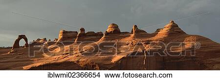 Picture - "Panoramic shot, stormy atmosphere, tourists at Delicate Arch, Arches National Park, Moab, Utah, United States of America, USA". Fotosearch