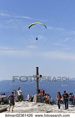 Stock Photograph - "Paraglider paragliding over the summit cross of Kehlstein Mountain, Berchtesgaden, Berchtesgadener Land, Upper Bavaria, Bavaria, Germany, Europe". Fotosearch