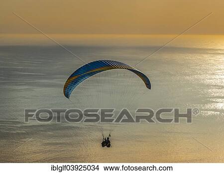 Picture - "Paraglider tandem jump, paraglider flying over the sea at sunset, Cape Town, Western Cape, South Africa, Africa". Fotosearch