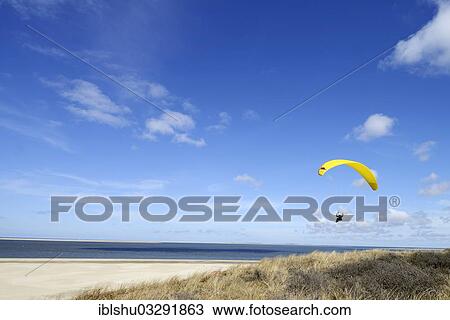 Stock Image - "Paragliding above the beach, De Cocksdorp, Texel, West Frisian Islands, North Holland Province, Netherlands". Fotosearch