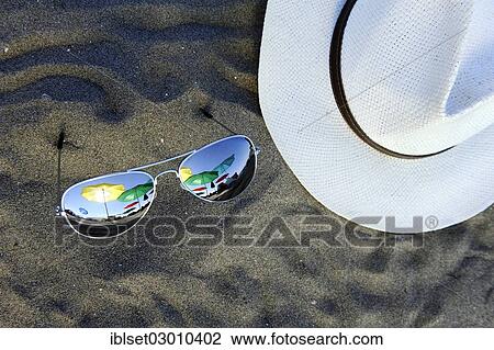 "Parasols are reflected in sunglasses lying in the sand, next to a white hat, Cavallino, Jesolo, Venedig, Italy, Europe" View Large Photo Image Stock Image - "Parasols are reflected in sunglasses lying in the sand, next to a white hat, Cavallino, Jesolo, Venedig, Italy, Europe". Fotosearch