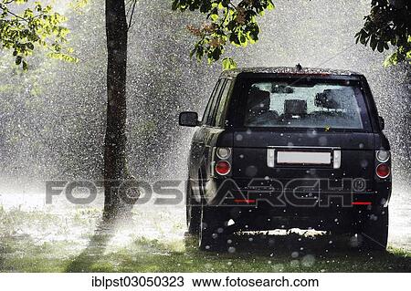 "Parked SUV in the rain, sun shining through trees, Austria, Europe" View Large Photo Image Stock Image - "Parked SUV in the rain, sun shining through trees, Austria, Europe". Fotosearch