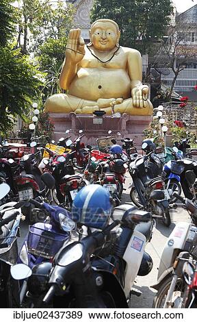 "Parking lot for motor scooters in front of a large golden Buddha statue, Chiang Rai, Thailand, Asia" View Large Photo Image Stock Photo - "Parking lot for motor scooters in front of a large golden Buddha statue, Chiang Rai, Thailand, Asia". Fotosearch