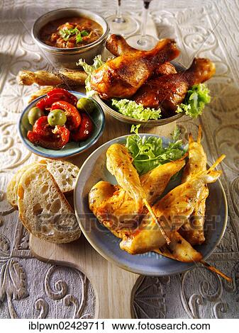Stock Image - Party buffet food with chicken satay and BBQ drum sticks. Fotosearch