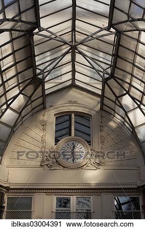 Stock Image - "Passage Jouffroy, a historic covered shopping arcade of 1846, with the historic clock, Grands Boulevards, 2nd Arrondissement, Paris, Ile-de-France, France, Europe". Fotosearch