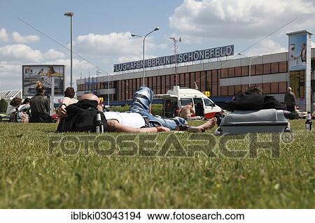 Picture - "Passengers waiting for their flights on the lawn in front of the Berlin-Schoenefeld airport terminal building, Schonefeld, Berlin, Berlin, Germany, Europe". Fotosearch