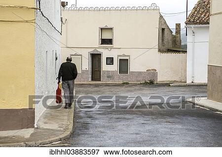 Stock Photo - "Passerby walking down a street, La Portera, Province of Valencia, Spain, Europe". Fotosearch