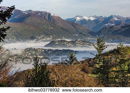"Patches of fog over Lugano on an autumn morning, seen from San Grato Botanic Park, Carona TI, Lugano, Canton of Ticino, Switzerland, Europe" View Large Photo Image Stock Image - "Patches of fog over Lugano on an autumn morning, seen from San Grato Botanic Park, Carona TI, Lugano, Canton of Ticino, Switzerland, Europe". Fotosearch