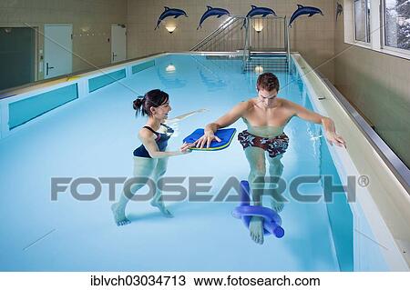 Stock Image - Patient and physiotherapist during underwater therapy. Fotosearch