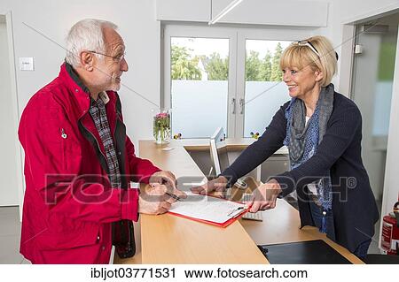 "Patient filling in a form at the reception of a dental office, Germany, Europe" View Large Photo Image Stock Image - "Patient filling in a form at the reception of a dental office, Germany, Europe". Fotosearch