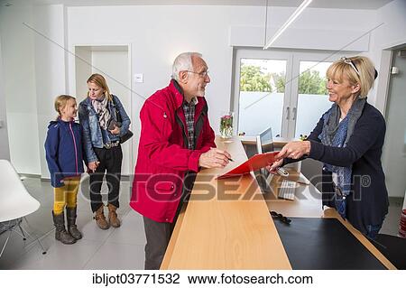 "Patient filling in a form at the reception of a dental office, Germany, Europe" View Large Photo Image Stock Image - "Patient filling in a form at the reception of a dental office, Germany, Europe". Fotosearch