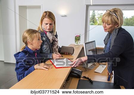 "Patients filling in a form at the reception of a dental office, Germany, Europe" View Large Photo Image Picture - "Patients filling in a form at the reception of a dental office, Germany, Europe". Fotosearch
