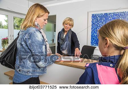 "Patients filling in a form at the reception of a dental office, Germany Germany" View Large Photo Image Stock Photography - "Patients filling in a form at the reception of a dental office, Germany Germany". Fotosearch