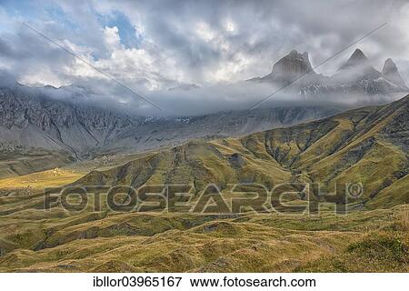 Stock Photo - "Pelvoux landscape with the Les Aiguilles d'Arves mountain between fog and clouds, Pelvoux, Dauphine Alps, Savoie, France, Europe". Fotosearch