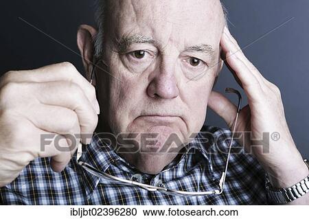Pensive senior holding his glasses in his hand View Large Photo Image Stock Image - Pensive senior holding his glasses in his hand. Fotosearch